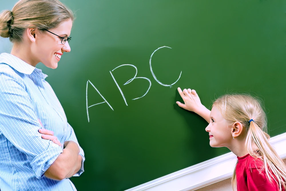 teacher with student at chalkboard