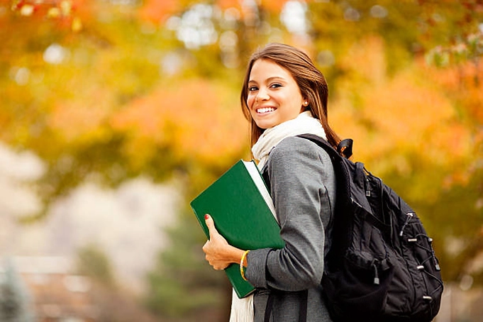 female student with backpack smiling at camera